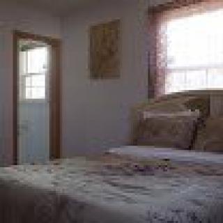 A cozy bedroom with a bed near a window and an open door.