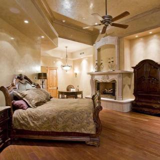 A luxurious and spacious bedroom with elegant furnishings and a cozy fireplace.