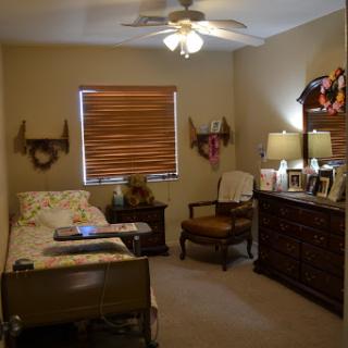 A cozy and well-decorated bedroom featuring a comfortable bed, a stylish chair, and warm lighting.