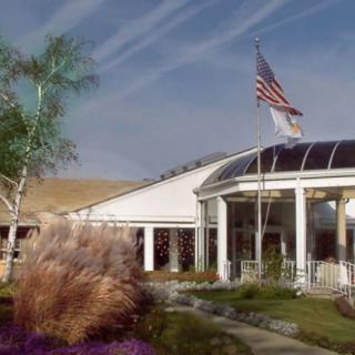 A modern building with an American flag and clear skies.
