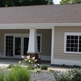 A small residential building with a well-maintained garden and patio.