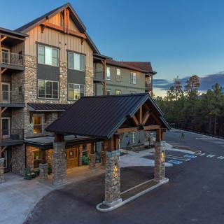 A rustic-style hotel building with a wooden exterior and a parking area.
