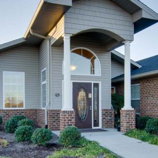A modern house entrance with a covered porch and columns.