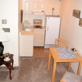 A compact kitchen and dining area in an apartment with simple furnishings.