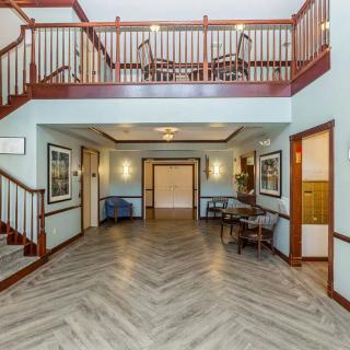 A spacious foyer featuring a wooden staircase and elegant decor.