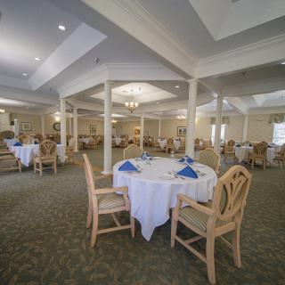 Spacious dining area with elegantly set tables and comfortable seating.