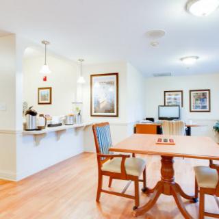A modern kitchen and dining area with wooden flooring and bright lighting.