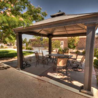 A cozy gazebo surrounded by greenery, perfect for relaxation and outdoor gatherings.