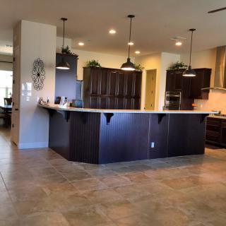 A modern kitchen with a central island and pendant lighting.