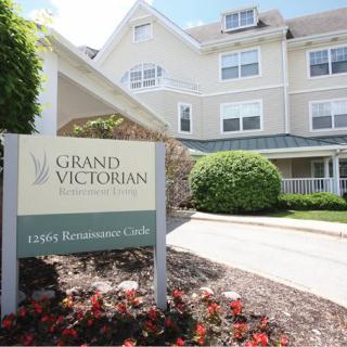 Entrance of Grand Victorian Living Retirement Community with well-maintained landscaping.