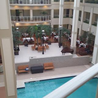 A serene indoor hotel environment featuring a pool and dining area.