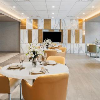 A modern restaurant interior with elegantly set tables, comfortable seating, and stylish decor.