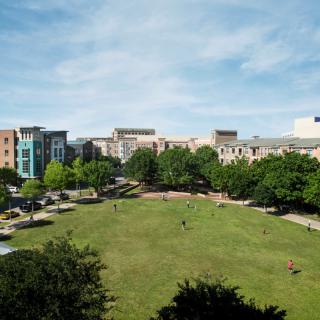 A scenic view of a city park surrounded by buildings under a clear sky.