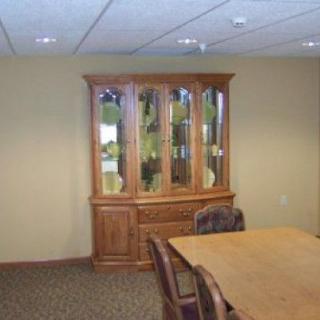 A dining room with a wooden cabinet and table.