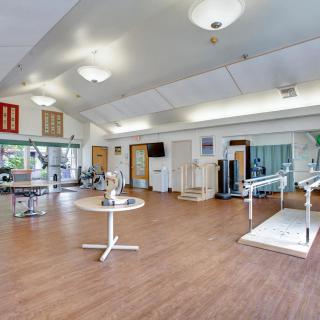 A spacious rehabilitation center equipped with various exercise machines and therapy equipment.