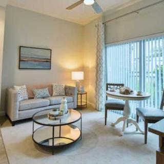 A modern living room with a cozy seating area, stylish coffee table, and a dining nook by the window.