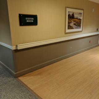 A view of a hallway featuring a sign and artwork on the wall.