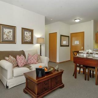 A cozy living room with a sofa, coffee table, and nearby dining area.