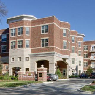 A modern brick residential apartment building with multiple stories and large windows.