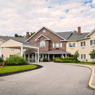 A large residential building with a landscaped driveway.