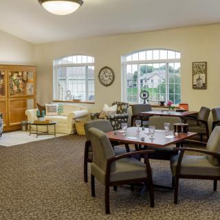 A cozy living room with a seating area and large windows allowing natural light to fill the space.