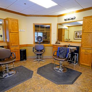 A modern barber shop interior featuring styling chairs and mirrors.