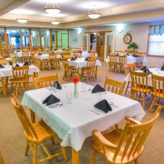 A spacious restaurant dining room with neatly arranged tables and chairs, set for dining.