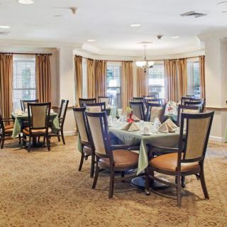 A well-lit dining room with elegantly set tables and comfortable chairs.