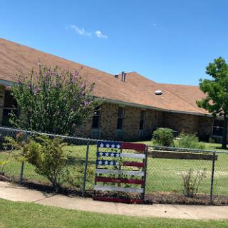 A charming house with a well-maintained garden and a decorative flag at the fence.