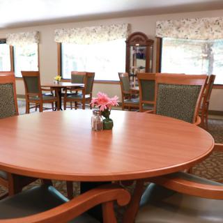 A cozy dining area with wooden furniture and a round table centerpiece.