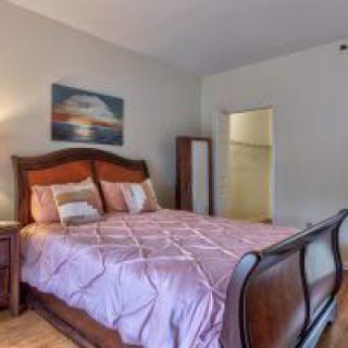A cozy bedroom with a large bed and wall artwork.