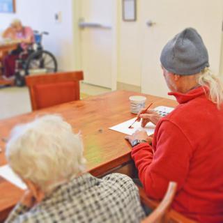 Elderly individuals participating in an art activity at a nursing home.