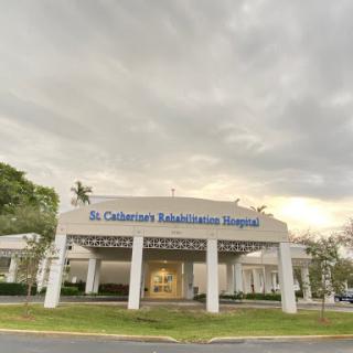 A view of St. Catherine's Hospital, showcasing its modern architecture against a cloudy sky.