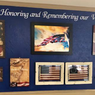 A tribute wall dedicated to honoring and remembering our veterans, featuring various artistic representations of the American flag.