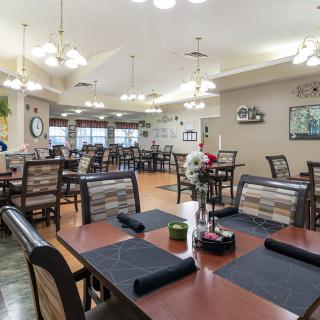 A spacious and well-decorated restaurant dining area with multiple tables and chairs arranged for guests.