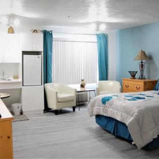 A modern and cozy bedroom with a white and blue color scheme.