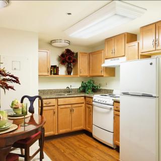 A cozy kitchen with wooden cabinets and a small dining area.