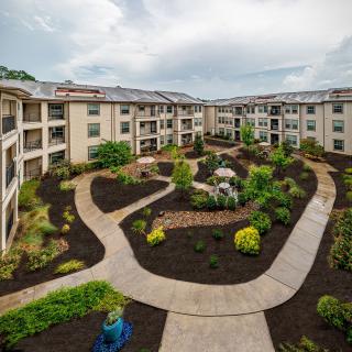 A view of a landscaped courtyard in an apartment complex with winding walkways.