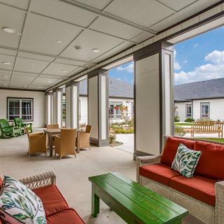 A covered outdoor patio with comfortable seating and tables, ideal for relaxation.