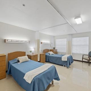 A spacious hospital room featuring two neatly made beds, designed for patient comfort.