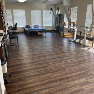 A spacious physical therapy room equipped with rehabilitation and exercise equipment.