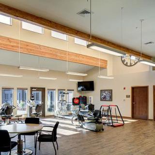 A rehabilitation center featuring exercise equipment and seating areas for therapy sessions.