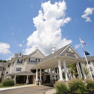 A large hotel with a welcoming entrance under a bright blue sky with fluffy clouds.