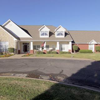 A suburban residential house with a large front lawn and driveway.