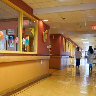 A hospital corridor with people walking.
