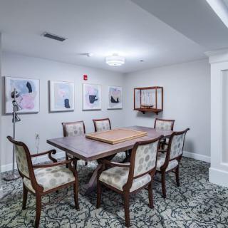 A formal dining room with elegant furniture and modern artwork on the walls.