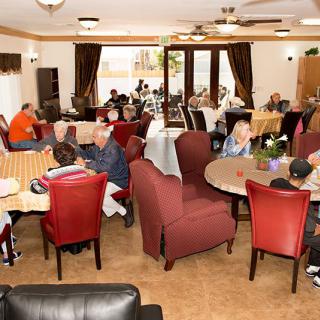 A busy dining area with people socializing at various tables.