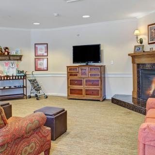 A cozy living room featuring a fireplace, television, and comfortable furniture.