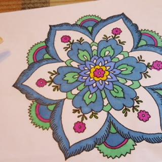 A vibrant mandala design featuring blue, green, and pink colors.