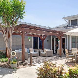 A cozy outdoor patio with a pergola and comfortable seating areas.
